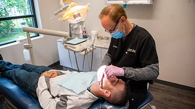 Dr. Burt of South Shore Dentistry checking on a patient's dental implants